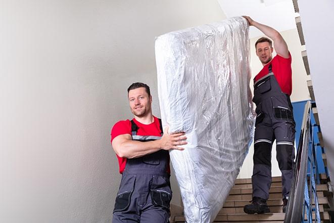 heavy lifting as a box spring is carried out of a house in Fort Blackmore